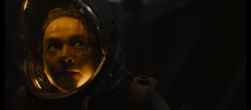 Cailee Spaeny fearfully anticipating something while inside a space helmet.