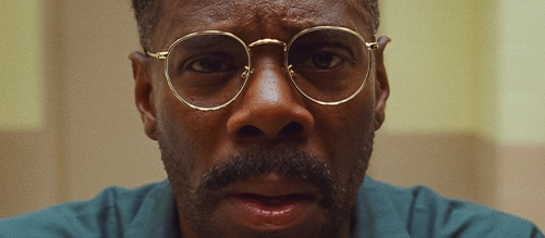 Colman Domingo, wearing gold glasses and staring directly into camera in the film 'Sing Sing'.